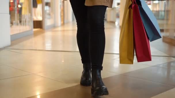 Regardez les jambes d'une femme marchant avec des sacs à provisions autour du centre commercial — Video