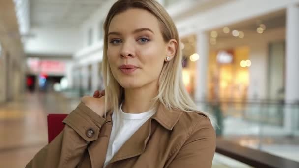Mädchen sieht entzückend aus, posiert mit Einkaufstüten im Einkaufszentrum — Stockvideo