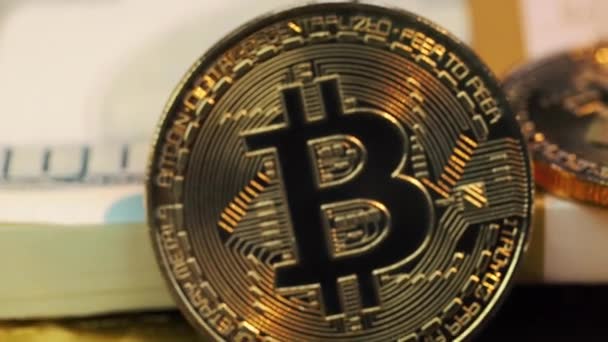 Goldene Bitcoins liegen auf dem Bündel Dollars — Stockvideo