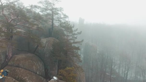 Adam ile sis kaplı dağın tepesinde oturan bir harita okur — Stok video