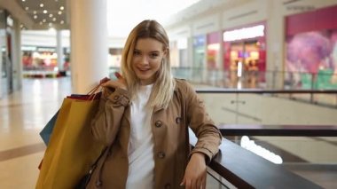 Sevimli kadın onu omuz ayakta alışveriş merkezinde alışveriş torbaları koyar