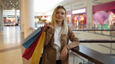 Sevimli kadın onu omuz ayakta alışveriş merkezinde alışveriş torbaları koyar