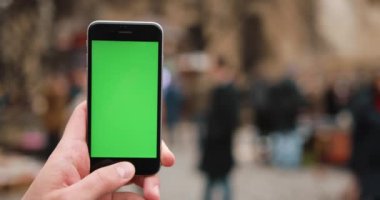 Erkek Close-Up holding smartphone şehir merkezinde açık havada eller. Yakın çekim. Hareket izleme. Chroma anahtar. Bahar zamanı. Dikey. Kırmızı sinema kamera 4 k atış