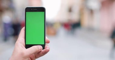 Erkek el smartphone, açık havada ve şehir merkezinde kullanarak yakın çekim. Yakın çekim. Hareket izleme. Chroma anahtar. Bahar zamanı. Dikey. Kırmızı sinema kamera 4 k atış