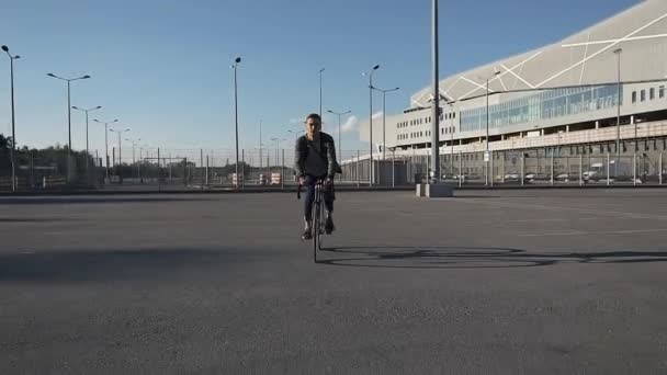 Giovane uomo va in bicicletta lungo la strada — Video Stock