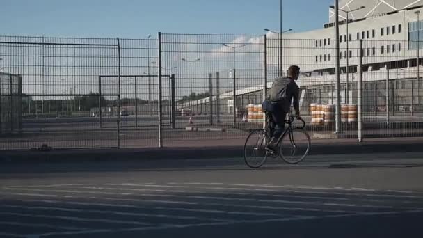 Joven pasea en bicicleta por la calle — Vídeos de Stock