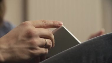 Adam bir kitap dizlerinin üzerinde tutar.
