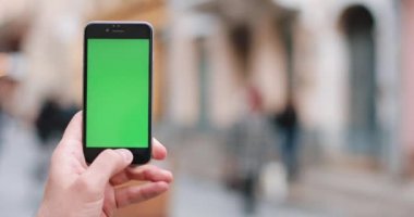 Erkek Close-Up holding smartphone şehir merkezinde açık havada eller. Yakın çekim. Hareket izleme. Chroma anahtar. Bahar zamanı. Dikey. Kırmızı sinema kamera 4 k atış