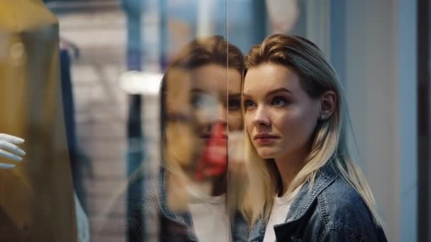 Γοήτευσε νεαρός ξανθιά γυναίκα στέκεται πριν από ένα παράθυρο εμφάνιση στο εμπορικό κέντρο — Αρχείο Βίντεο