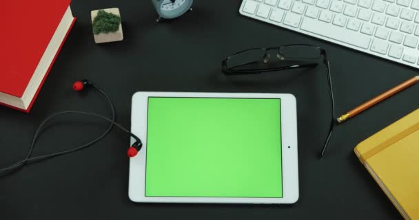 Tableta con pantalla verde se encuentra en la mesa de trabajo en la oficina — Vídeos de Stock