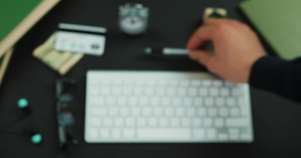 El hombre pone un bolígrafo en una mesa de trabajo antes que un teclado — Vídeo de stock