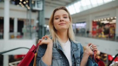 Kız alışveriş torbaları onun omuzlarında bir çarşıda ayakta tutan