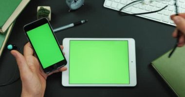 Adam onun gözlük yeşil ekran tabletiyle tarafından masanın üzerine koyar ve smartphone onun kolundan tutar