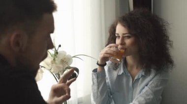 Sevimli kıvırcık kadın ve erkek parlak pencere önce oturup