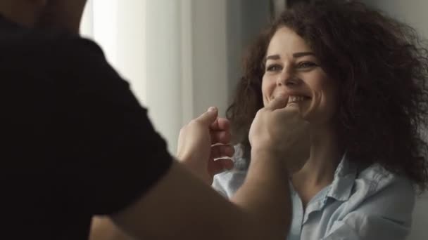 El hombre y la encantadora mujer rizada se sientan ante una ventana brillante — Vídeos de Stock