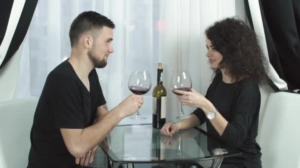 Mann und Frau trinken Wein sitzend vor dem Fenster — Stockvideo