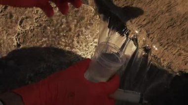 Bir test için pis su adam eldiven alır