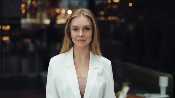 Attraktive blonde Frau blickt direkt in die Kamera, die im Einkaufszentrum steht — Stockvideo