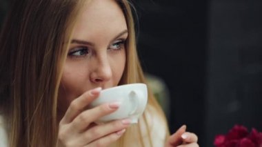 Çok güzel genç kadın kafede oturmuş kahvesini içer