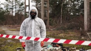 Biyo-tehlike takım elbise ve Gaz Maskeli adam kaybı tam topraklarında şerit arkasında duruyor