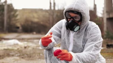 Su ve toprak analizi için biyo-tehlike takım elbise ve Gaz Maskeli adam alır