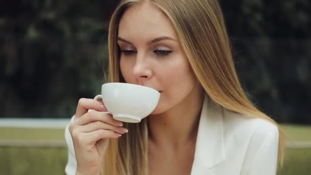 可爱的年轻妇女喝她的咖啡坐在咖啡馆里 — 图库视频影像