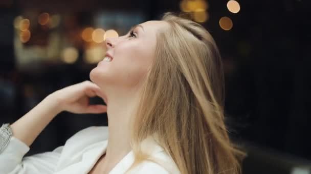 Schöne junge Frau blickt direkt in die Kamera und fixiert ihre Haare — Stockvideo