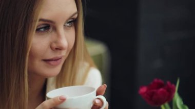 Çok güzel genç kadın kafede oturmuş kahvesini içer