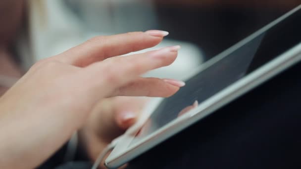 Zbliżenie, palcem womans pracę z tabletem na jej kolanach — Wideo stockowe