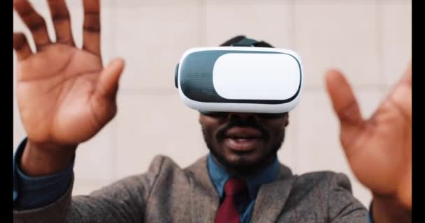 Hombre afroamericano juega con auriculares VR de pie afuera — Vídeo de stock