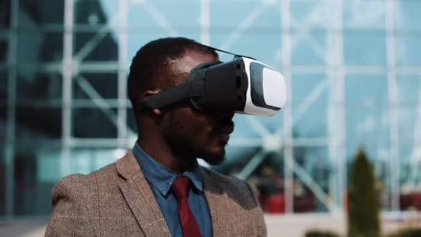 Afro-Amerikaanse man speelt met een Vr headset reputatie buiten — Stockvideo