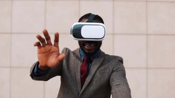 Hombre afroamericano juega con auriculares VR de pie afuera — Vídeos de Stock