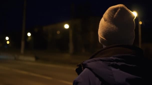 Un joven solitario pasea por la ciudad nocturna — Vídeo de stock