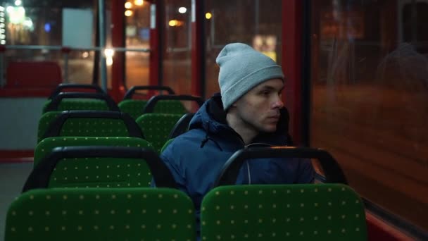 Solitario joven cabalga en un tranvía en la noche — Vídeo de stock
