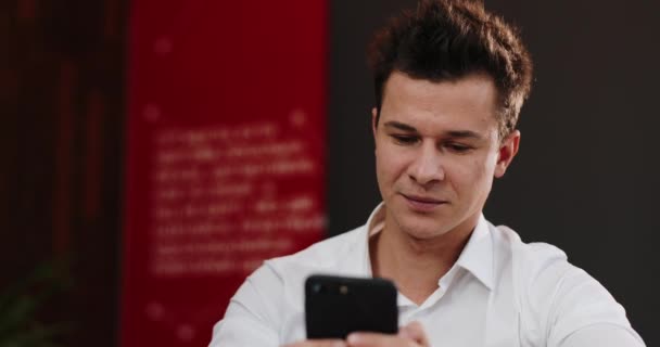 Homem feliz trabalha com seu smartphone no escritório — Vídeo de Stock