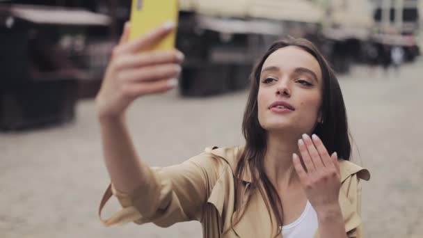 Happy Pretty Girl Making Selfie lub wideo Call Holding her Smartphone pionowy uśmiech i dmuchanie pocałunek do kamery. — Wideo stockowe