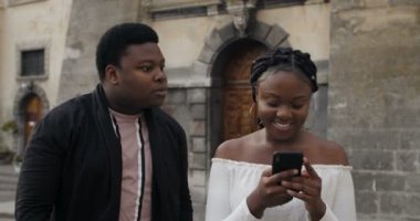 Gülümseyen kız telefonu kullanıyor ve adama dikkat etmiyor..