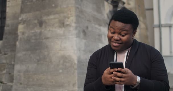 Mann benutzt Smartphone und tippt auf die Stirn. — Stockvideo