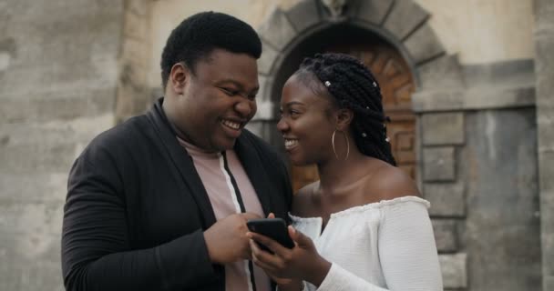 笑顔のカップルはスマートフォンで写真を見る. — ストック動画