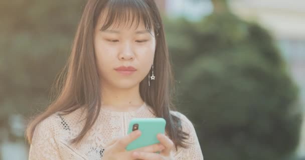 Jolie asiatique femme en utilisant mobile . — Video