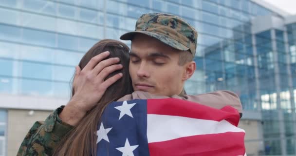 Soldat umarmt Mädchen mit amerikanischer Flagge. — Stockvideo