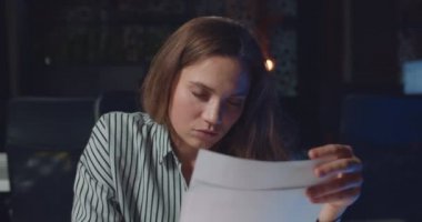 Uykulu iş kadınının gece ofisindeki belgelerle çalışırken gözlerini kapatması. Uzun saatler çalışan yorgun bayan ofis çalışanı. Aşırı çalışma ve çalışma kavramı..