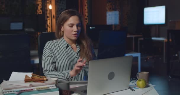 Kızgın kadın ofis müdürü gece geç saatlere kadar çalışırken bilgisayarını kapatıyor. Stresli kız iş yerinde sakinleşmek için yoga yapıyor ve derin derin nefes alıyor. Aşırı çalışma kavramı. — Stok video