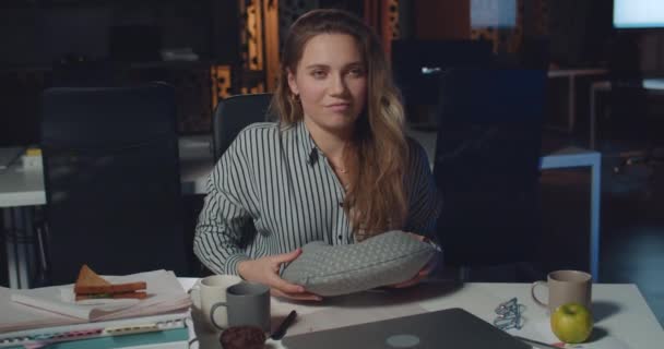 Tatmin olmuş iş kadını laptopunu kapatıyor, boyun yastığı takıyor ve uyumaya çalışıyor. Genç bayan ofis çalışanı işini bilgisayarda bitiriyor ve işyerinde uyuyor. İşçilik kavramı — Stok video