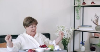 Soygunda yaşlı ve mutlu bir kadın sabah kahvaltı yaparken kameraya bakıyor. Olgun, güzel bir kadın yemek dolu, yatakta oturuyor ve nereden başlayacağını seçiyor..