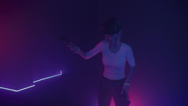 Mladá šťastná dívka nosit virtuální realita sluchátka držení ovladače joystick hrát ping pong na abstraktní neon osvětlení pozadí. VR, koncepce zábavy. — Stock video
