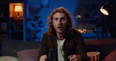 Genç duygusal adam yarışmaları izliyor ve elinde İtalyan bayrağı tutuyor. Yakışıklı milenyum sporcusu TV karşısında oturmuş milli takımı destekliyor. Boş zaman kavramı..