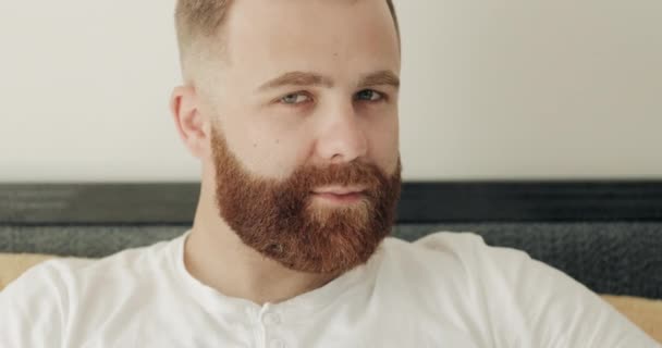 Close up view of cheerful bearded man having good mood and looking to camera. Portrait of handsome guy in 30s turning head and smiling while posing. Concept of people and emotions. — Stock Video