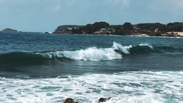 1人のサーファーは青い海の波のスプレーで回転し、他のサーファーに衝突する。海のライフスタイルをサーフィン。スローモーション。極端なスポーツの概念。背景にある建物. — ストック動画