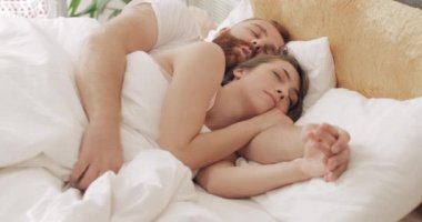 Sabahın erken saatlerinde uyurken yatakta kucaklaşan sevimli bir çiftin portresi. Yatakta yatıp rüya gören yakışıklı bir erkek. Aile ve ilişki kavramı..